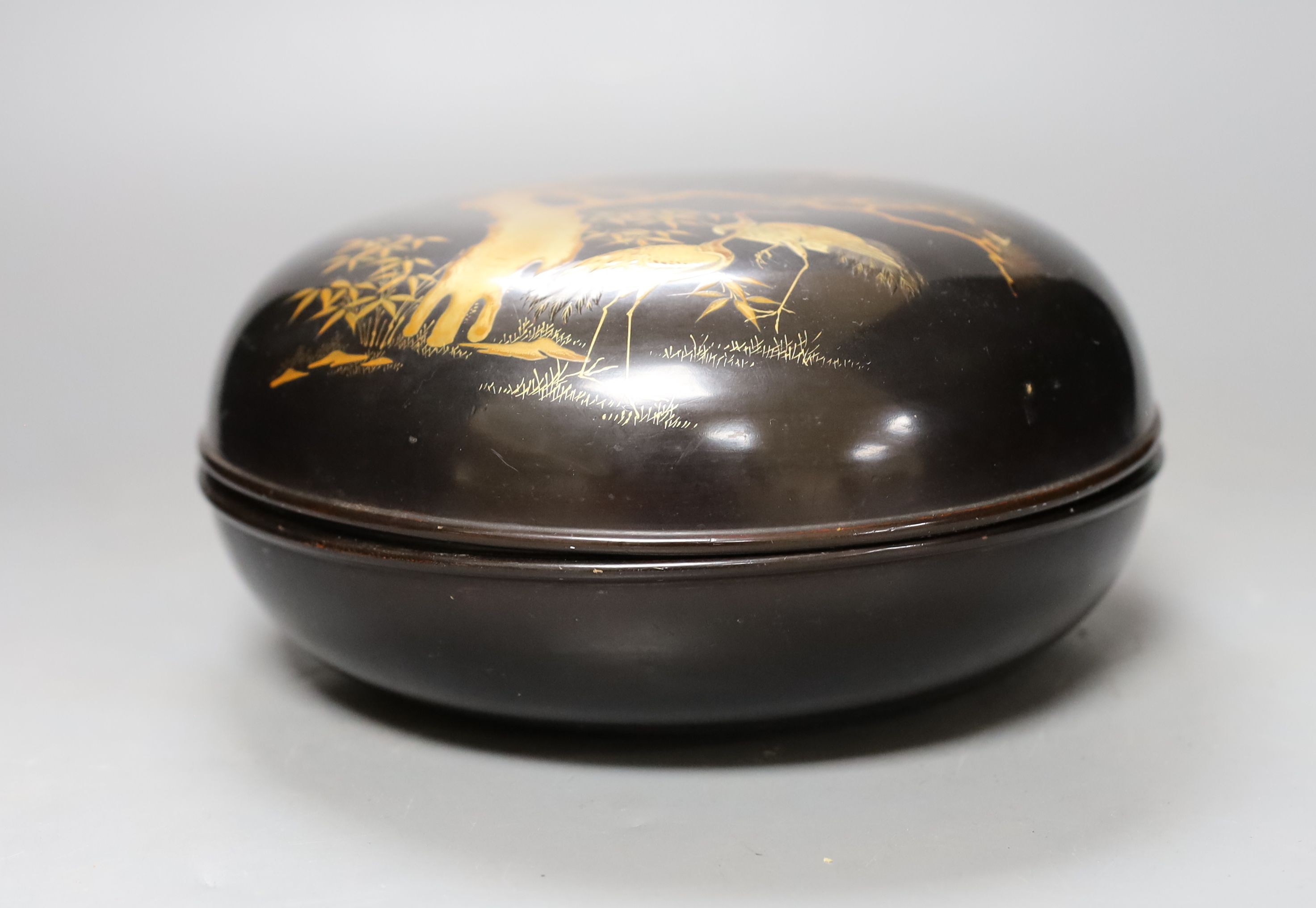 A Japanese lacquer box and cover, 21 cms diameter.